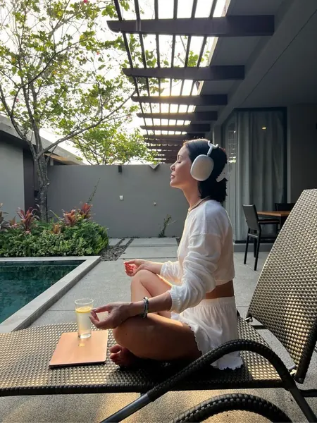 Woman meditating with headphones outdoors